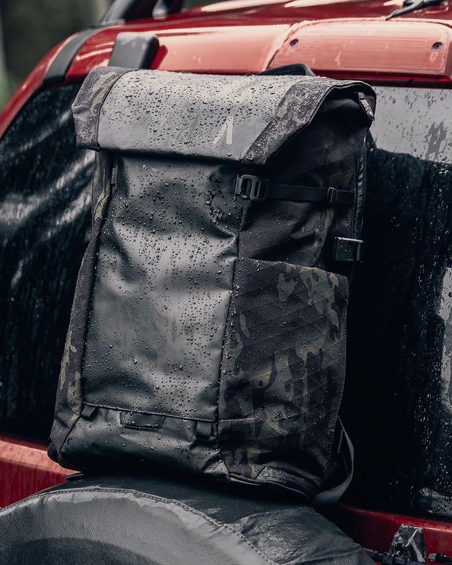 A waterproof camera backpack with raindrops on it
