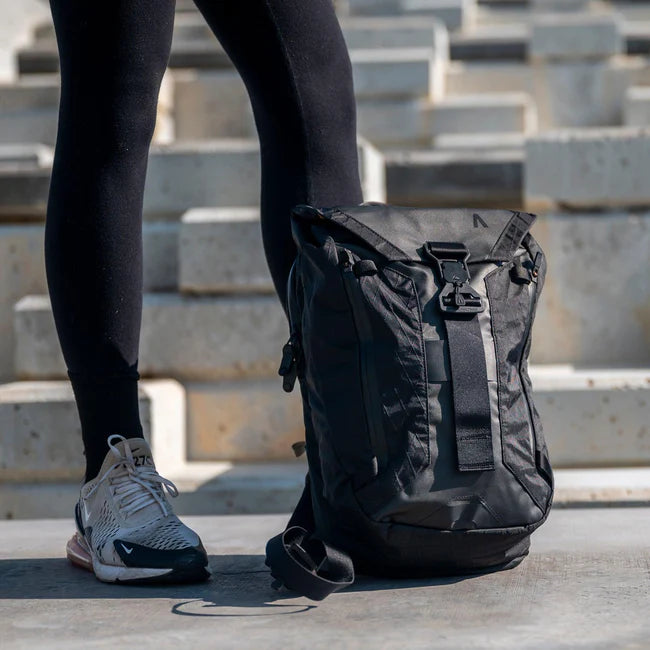 A woman with an Errant Sling X-Pac at her feet