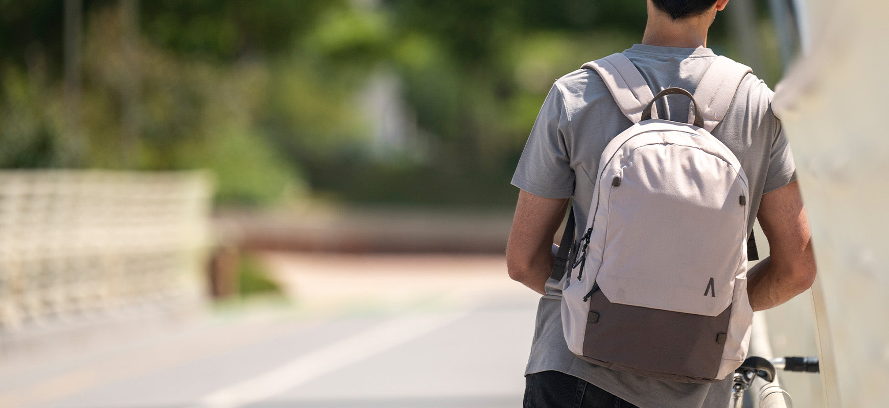 A man wearing a Rennen Recylced Daypack on a bridge.