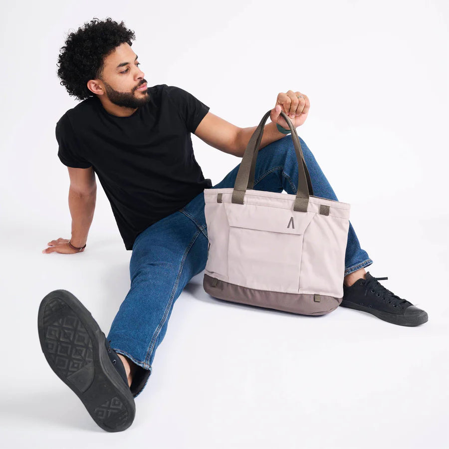Man sitting and posing with an eco-friendly tote bag