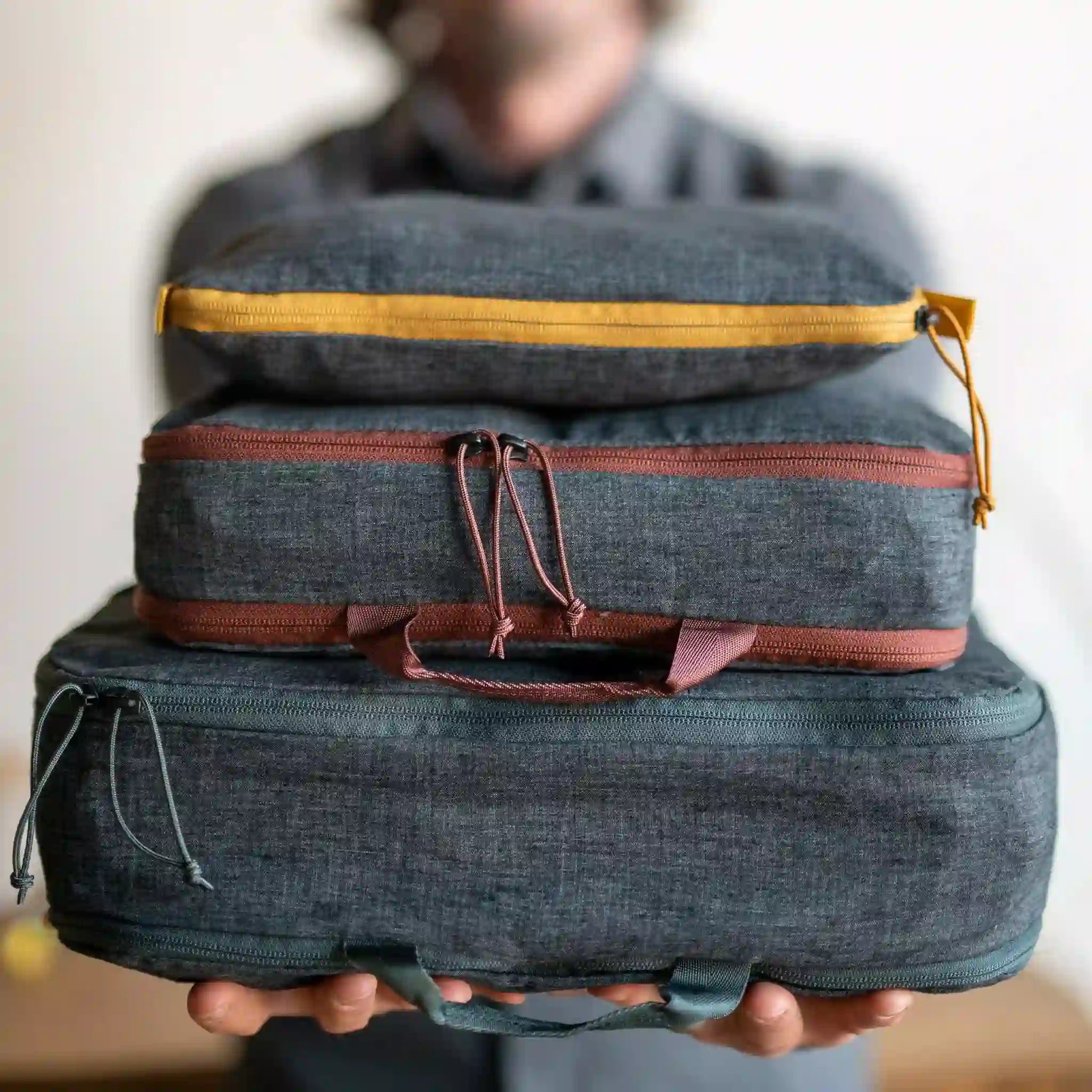 A man holds out a stack of filled Hemp Cubes by Boundary Supply.